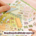 Close-up of a pre-cut PET sticker piece being peeled from a scene sticker sheet