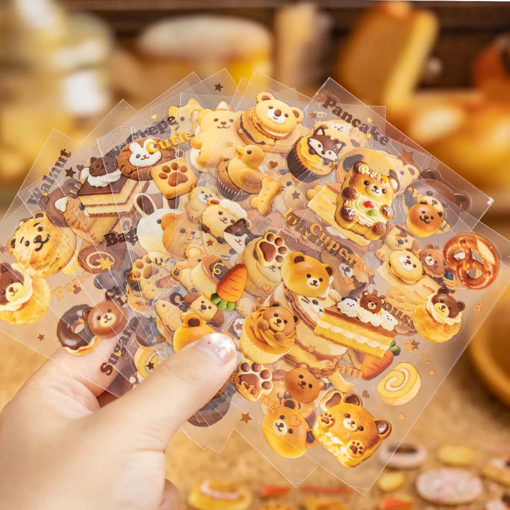 Assorted transparent PET sticker sheets from the Baking Story Journaling Sticker Set held in hand