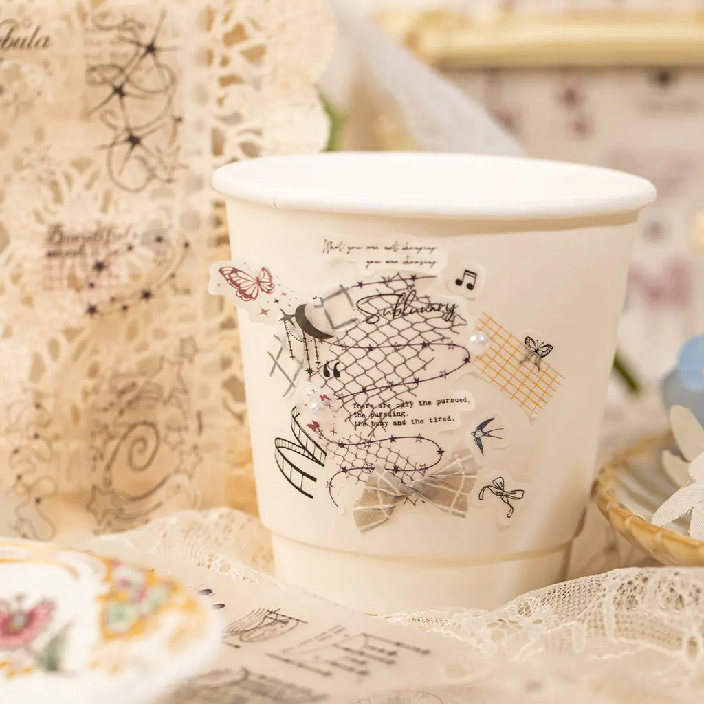 Close-up of a transparent floral line-art sticker being lifted with tweezers