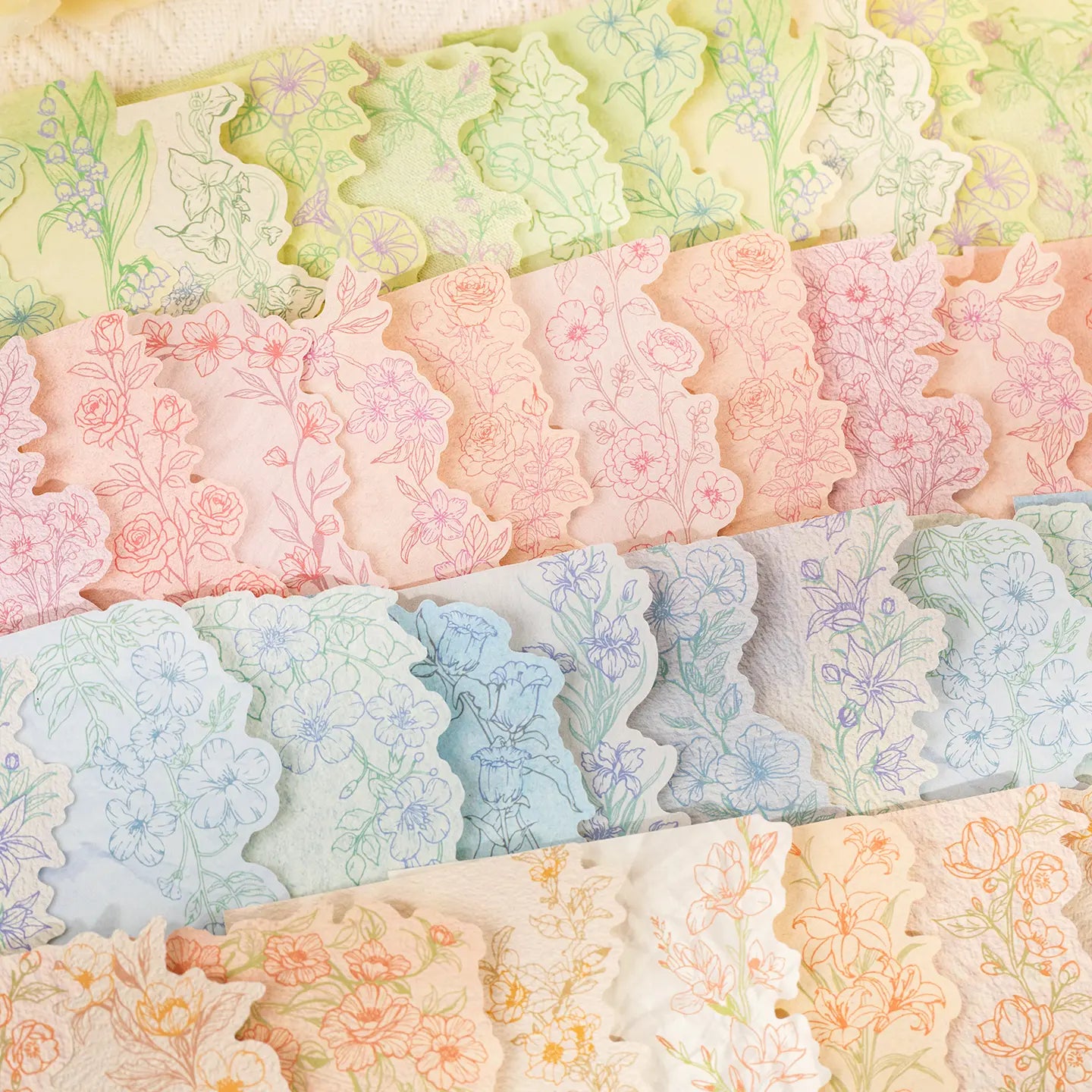 Close-up of pastel floral journaling stickers with scalloped botanical edges