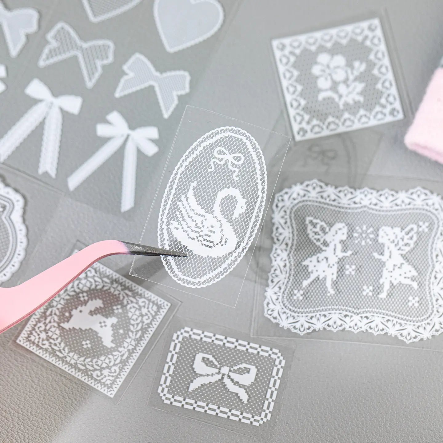 Close-up of a white lace-style decorative sticker being held with tweezers from the Breathing Space Journaling Sticker Set