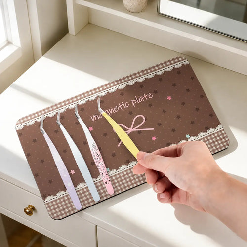 Brown bow magnetic tweezer storage board on a desk holding craft tweezers for sticker and DIY projects