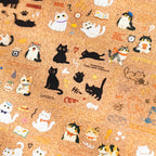 Cat Diary Journaling Sticker Set displayed on a cork board with assorted white, black, and kitten sticker designs