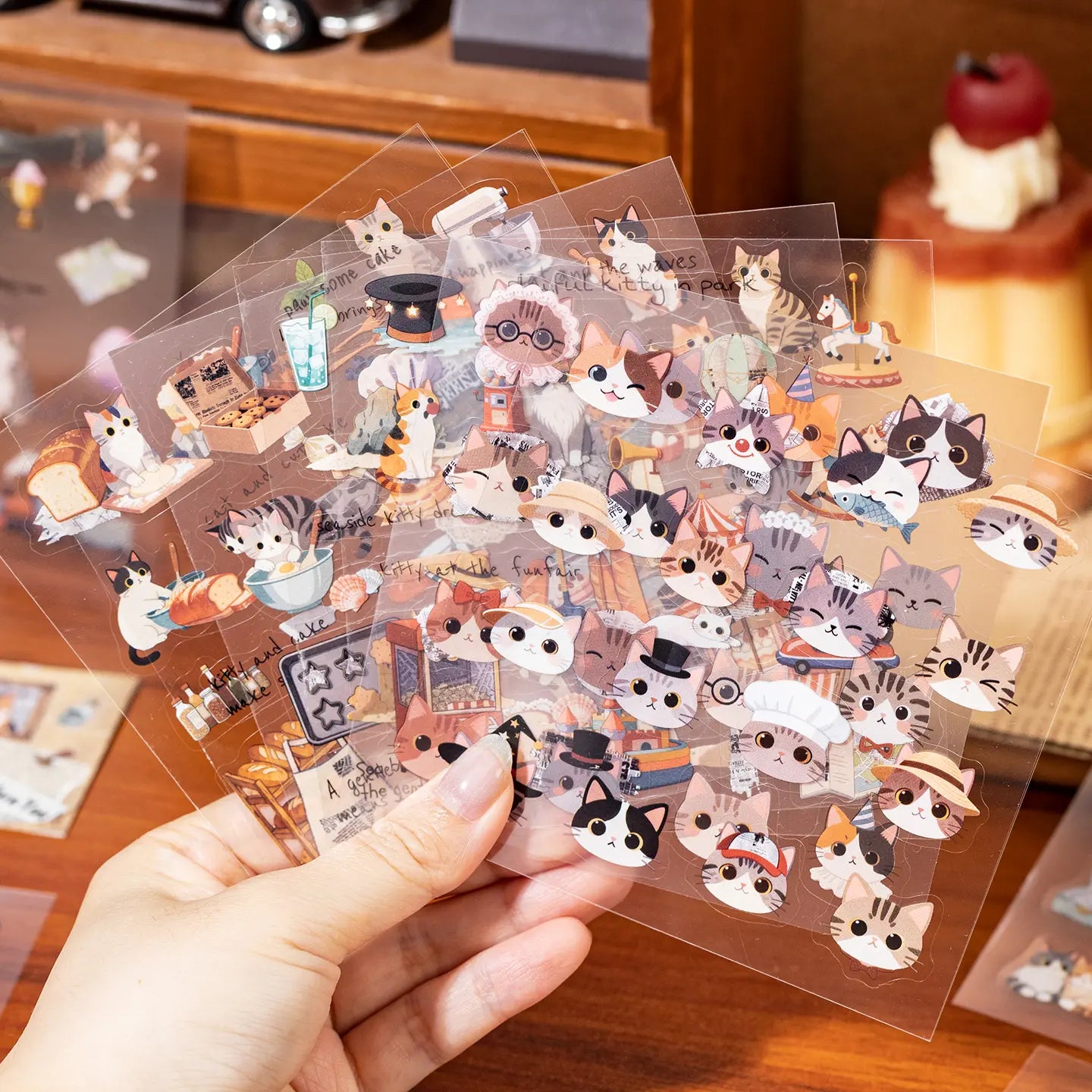 Hand holding transparent PET cat journaling sticker sheets from the Doodle Paper Journal set