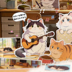 Close-up of a Cat Journey sticker scene with a cat playing guitar, music notes, and cozy room details