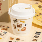 Cat stickers used to decorate a paper cup with fish, stars, and playful cat designs