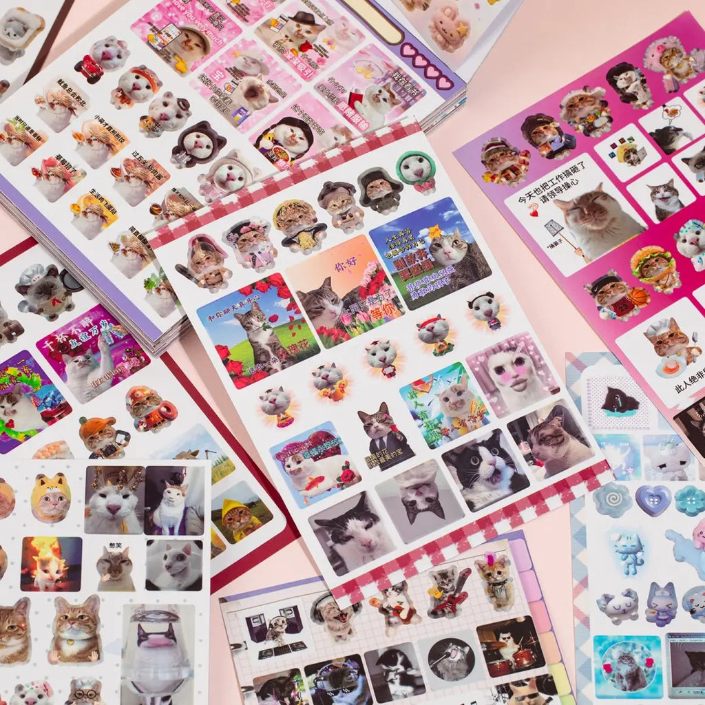 Close-up flat lay of Cat’s Day sticker sheets with photo-style cats, captions, frames, and decorative collage elements