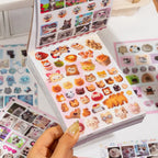 Open Cat’s Day sticker book showing cat-themed sticker sheets with food-shaped cats, photo frames, and colorful decorative details