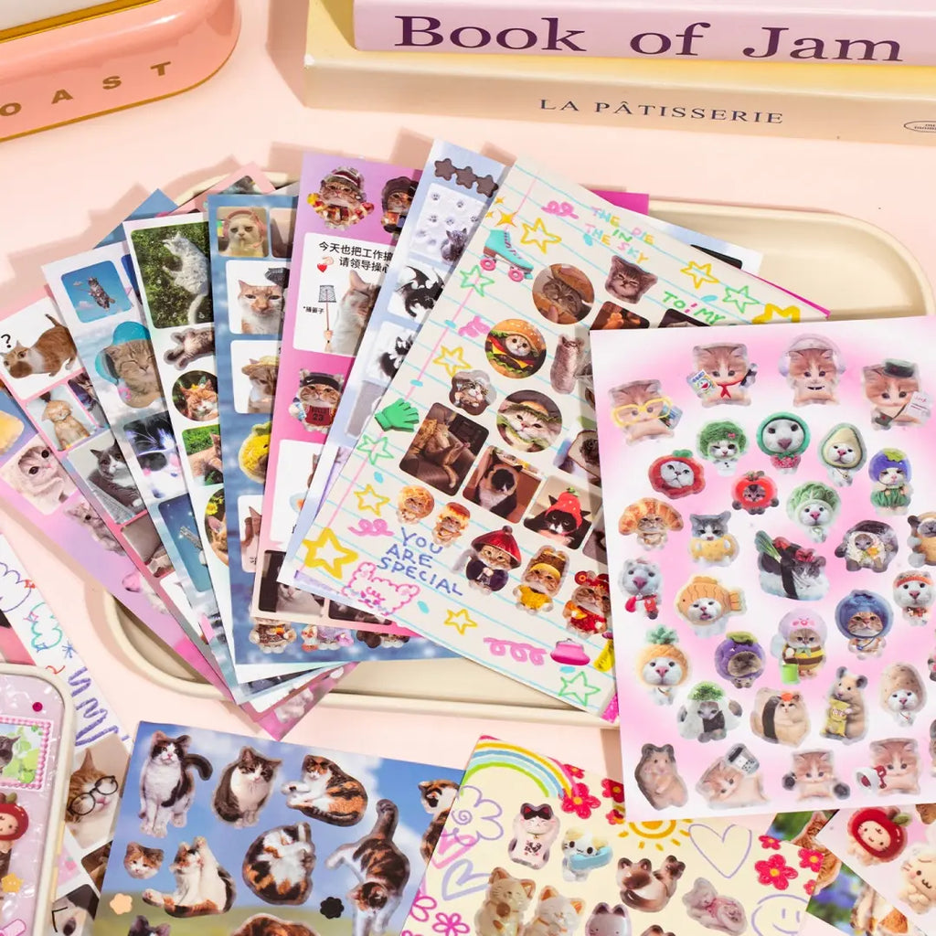 Cat’s Day sticker sheets arranged in a flat lay with photo-style cats, colorful frames, bows, hearts, and playful journal accents