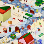 Close-up of Christmas buildings, decorations, and characters placed on the numbered snowy scene card