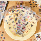Clear and matte cat sticker sheets displayed with patchwork-style cat illustrations