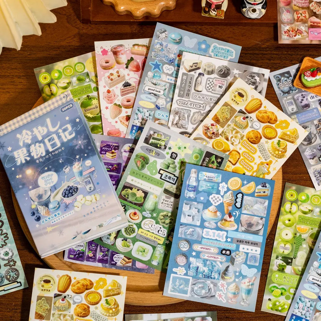 Cool Fruit Diary sticker book with fruit, dessert, drink, lemon, melon, and blueberry sticker sheets arranged on a wooden tray