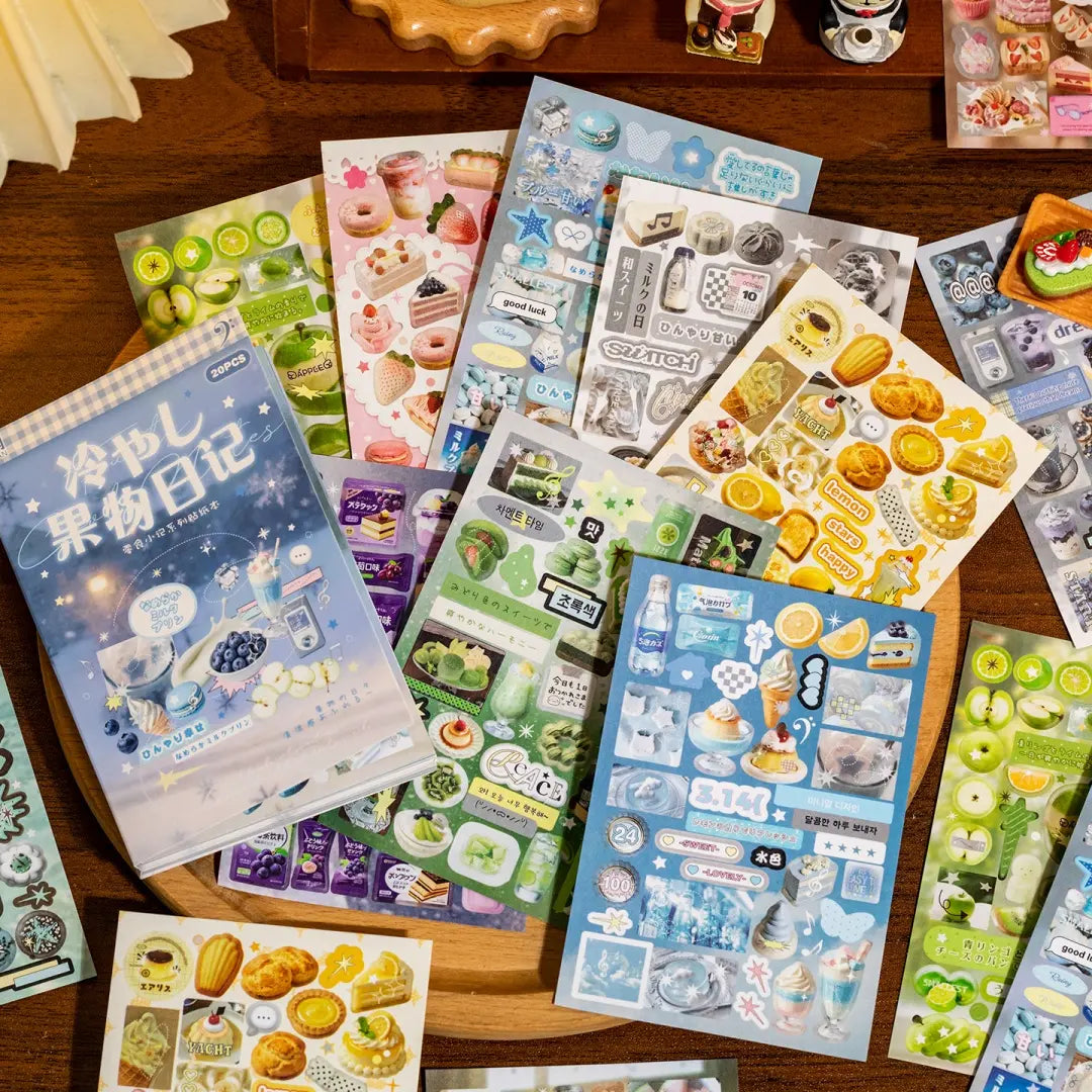 Cool Fruit Diary sticker book with fruit, dessert, drink, lemon, melon, and blueberry sticker sheets arranged on a wooden tray