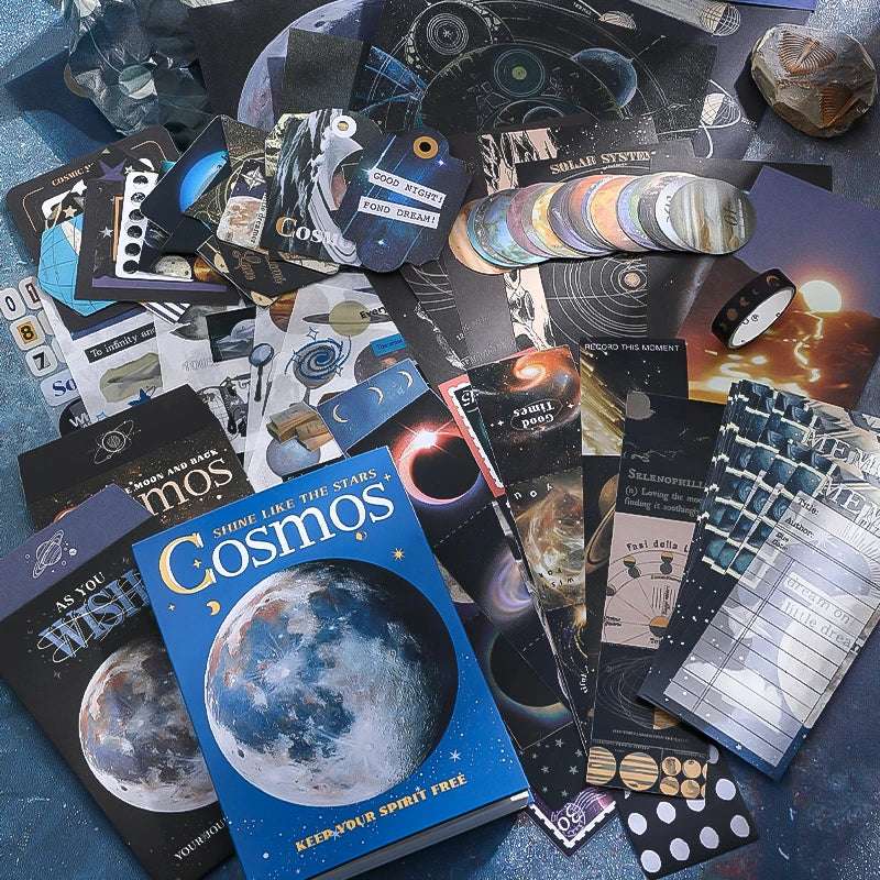 Cosmic Mystery Junk Journal Kit celestial ephemera flat lay with moon papers, stickers, cards, and dark blue collage pieces