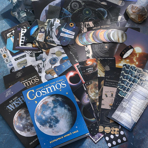Cosmic Mystery Junk Journal Kit celestial ephemera flat lay with moon papers, stickers, cards, and dark blue collage pieces