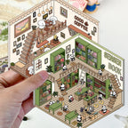 Hand holding the panda bookstore and Coco Coffee 3D scene sticker designs as finished miniature room cards