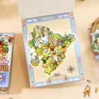 Finished Creekside Ferry mini scene displayed on a small base card with trees, ruins, flowers, and compass detail