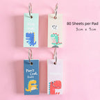 Dinosaur Ring memo pad random design with hanging ring format for portable notes and journal ideas.