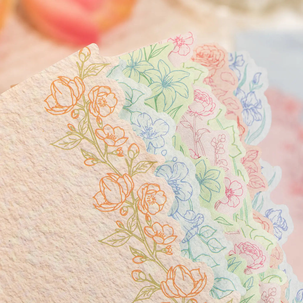 Close-up of lightweight paper journaling stickers with floral line art and scalloped edges