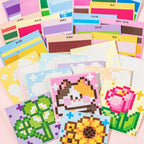 Flower Garden pixel mosaic scene cards and sticker sheets spread out on a pink background