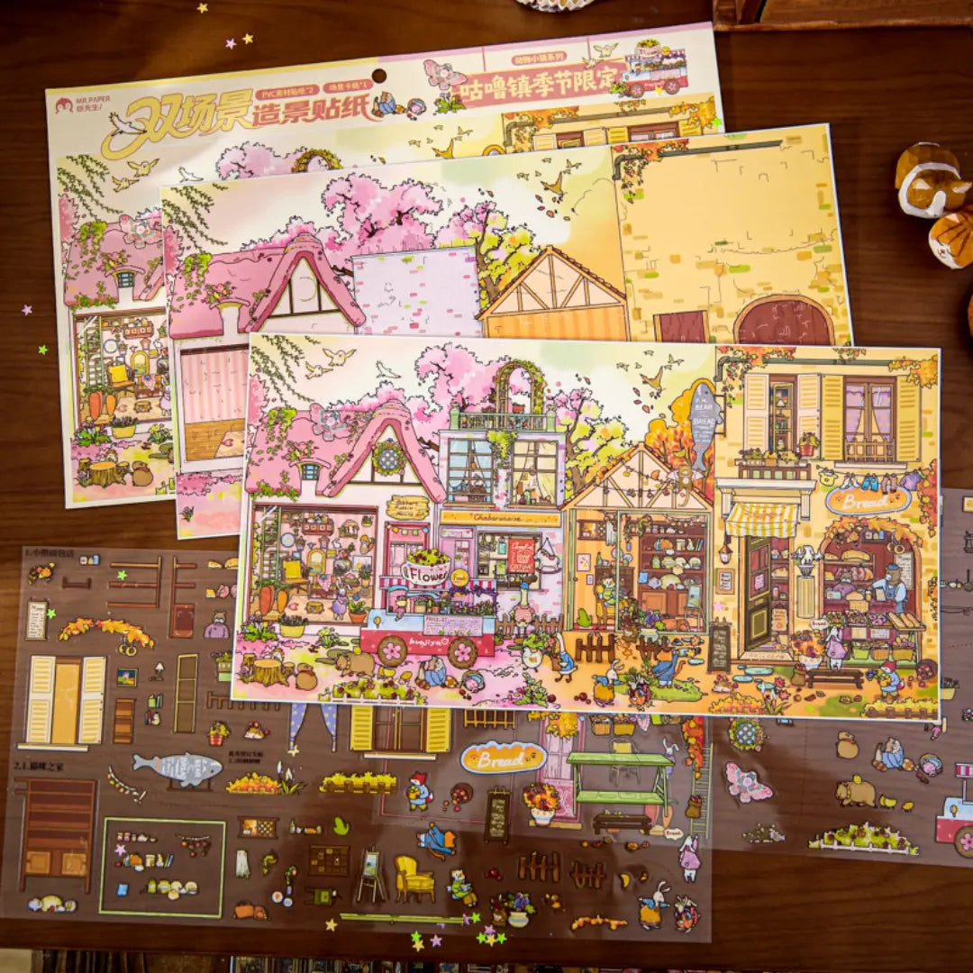 Gulu Town Seasonal Limited Edition scene backboard and PVC sticker sheets laid out on a wooden desk