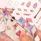 Close-up of small dollhouse stickers being placed on the Lolita Dollhouse scene background