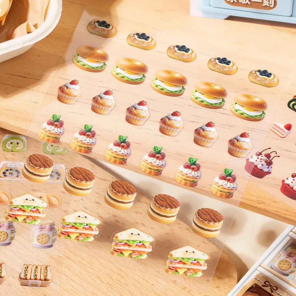 Close-up of mini food sticker elements including sandwiches, tarts, cupcakes, burgers, and small desserts