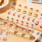 Close-up of mini food sticker elements including sandwiches, tarts, cupcakes, burgers, and small desserts
