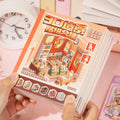 Mini Store Owner 3D Scene Sticker Book held in hand with bookstore cover and colorful scene pages