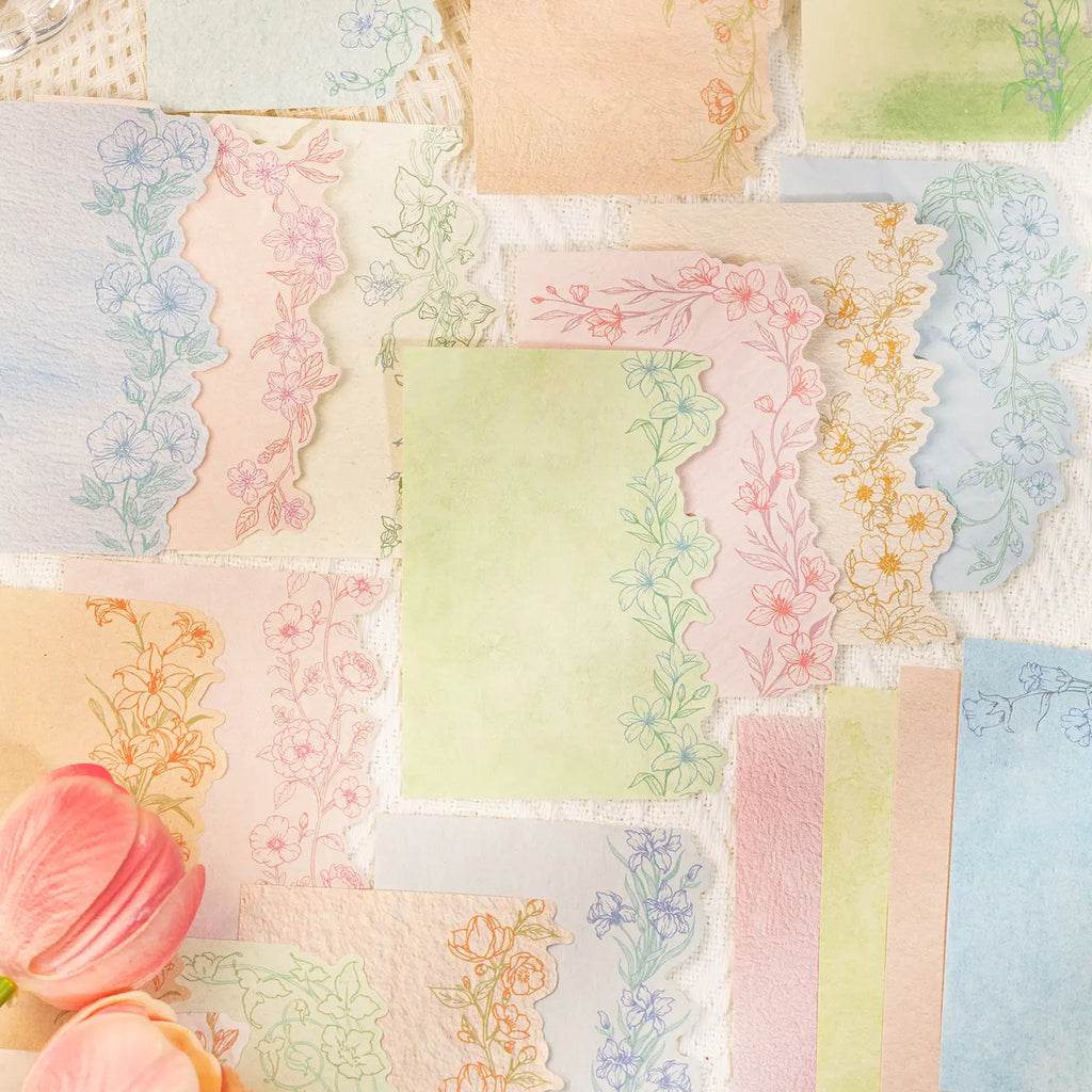 Flat lay of pastel botanical journaling stickers in green, pink, blue, and cream tones