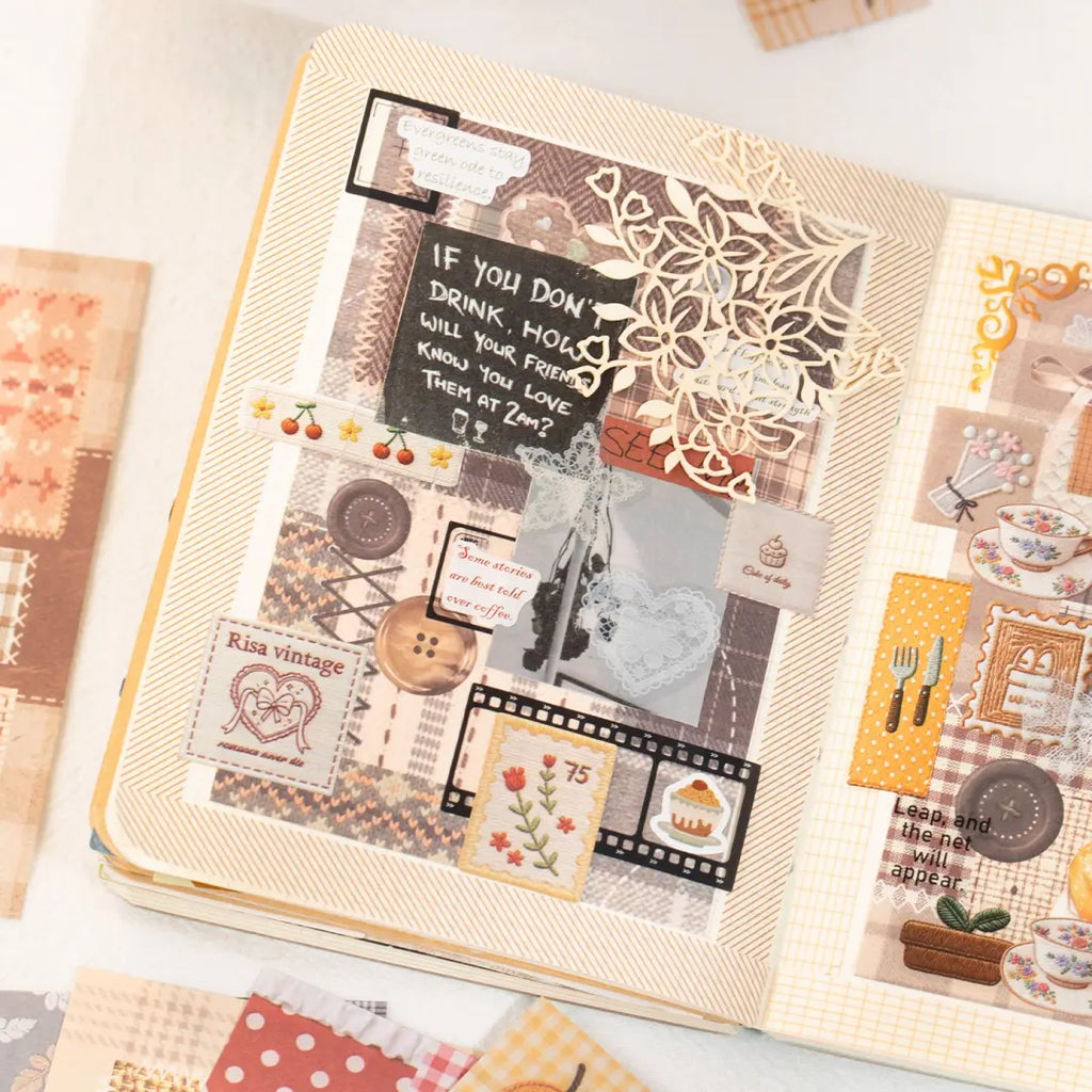 Close-up of a journal page decorated with brown patchwork stickers, lace, buttons, floral details, and vintage collage layers