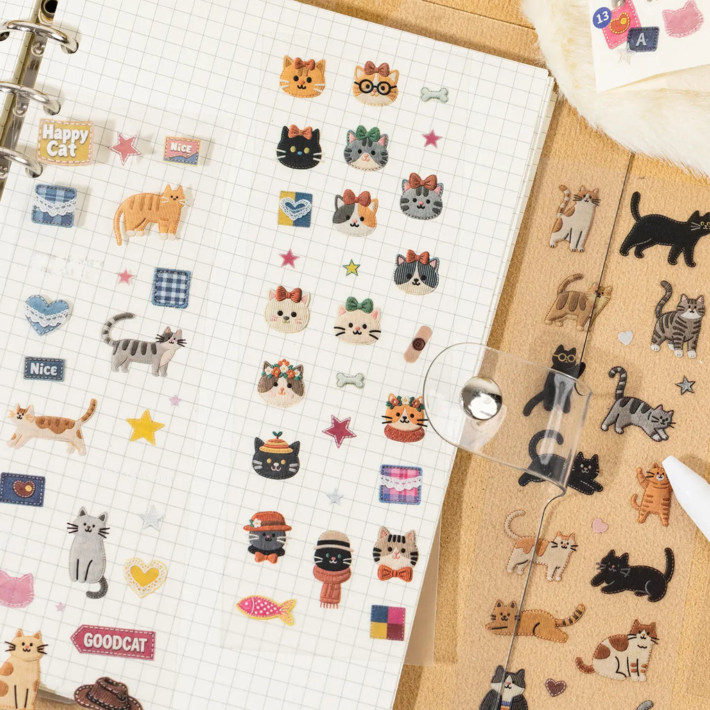 Patchwork-style cat stickers used on a grid journal page
