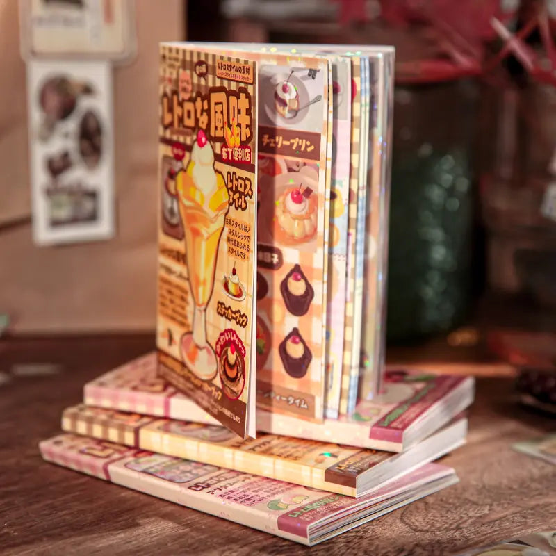 Pudding Convenience Store Retro Vibe Journaling Sticker Book with dessert-themed sticker pages stacked on a wooden table