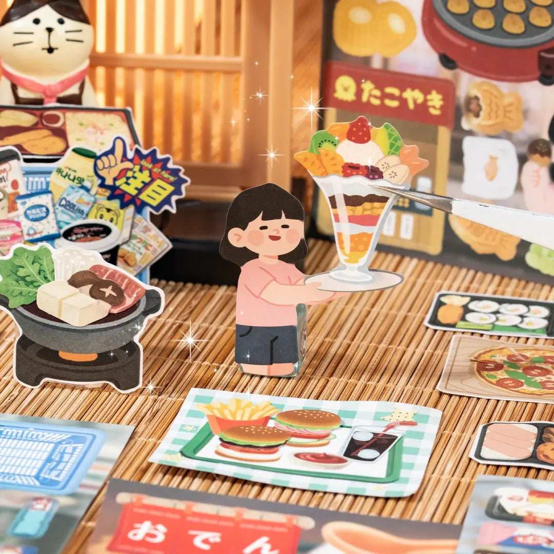 Close-up of food journaling stickers showing a dessert cup, hot pot, burgers, snacks, and a character holding a parfait