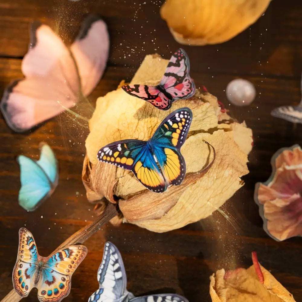 Close-up of butterfly stickers placed around dried flowers in a vintage journaling scene