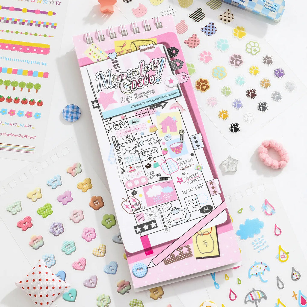 Soft Scripts Journaling Sticker Book with pastel pink cover displayed among paw print, button, and decorative stickers