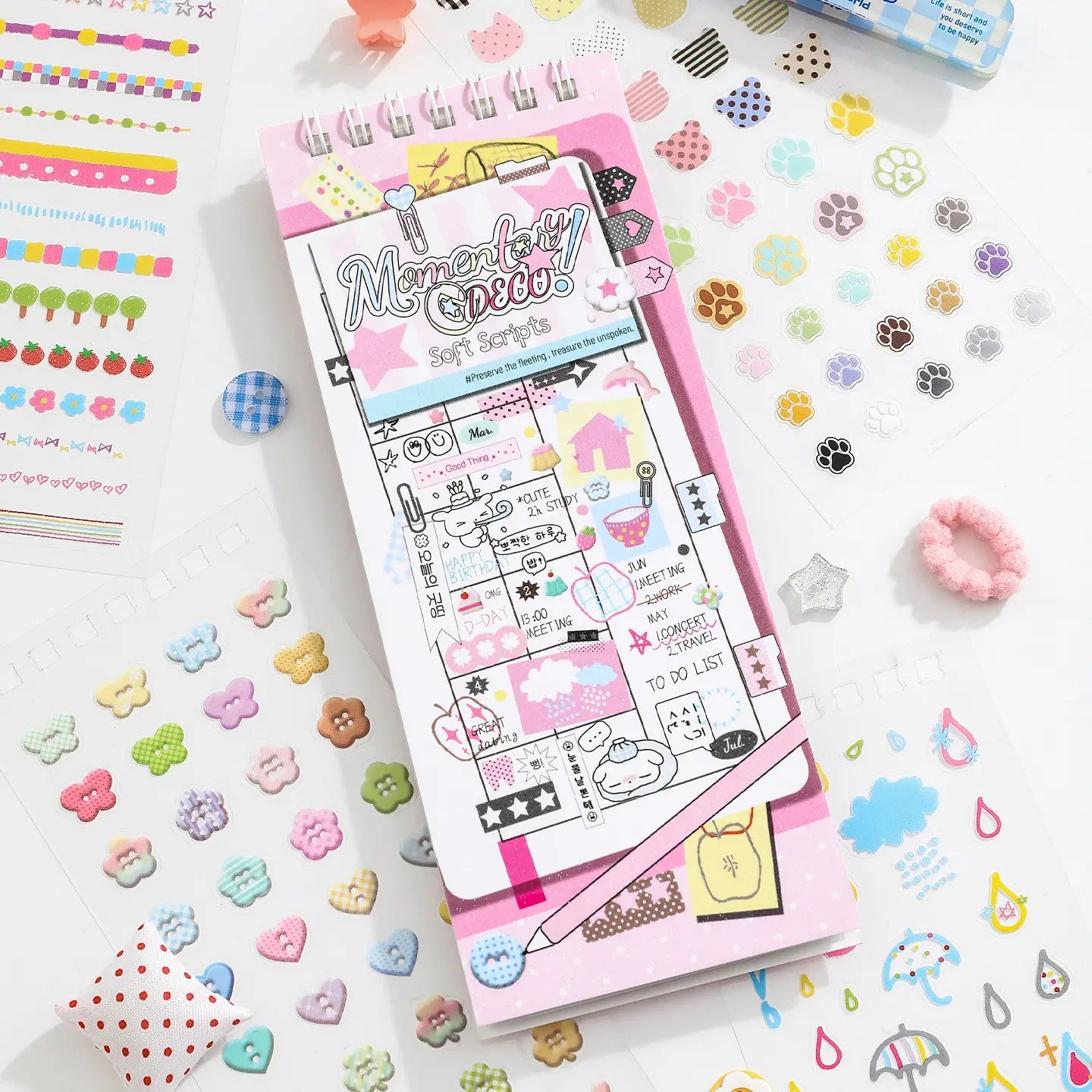 Soft Scripts Journaling Sticker Book with pastel pink cover displayed among paw print, button, and decorative stickers