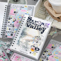 Strong Valley journaling sticker set displayed with spiral notebooks, pastel sticker sheets, a keyboard, and a coffee cup