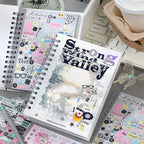 Strong Valley journaling sticker set displayed with spiral notebooks, pastel sticker sheets, a keyboard, and a coffee cup