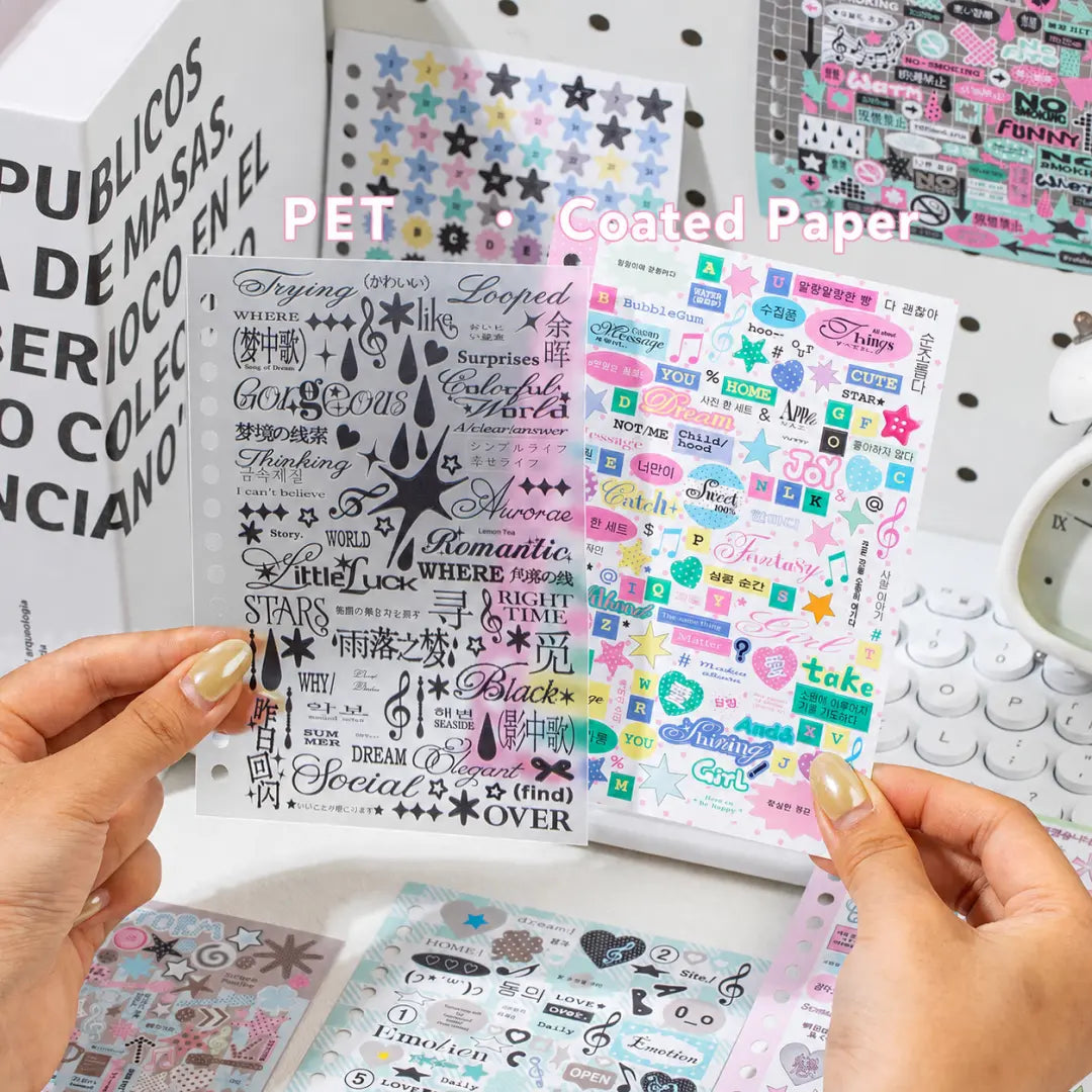 Strong Valley sticker sheets showing a matte transparent PET sheet beside a coated paper sheet with colorful words, stars, and graphic elements