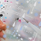 Close-up of a matte transparent weather-themed sticker sheet with rain, stars, arrows, and Japanese-style text accents