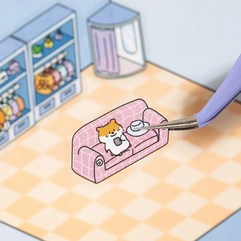 Placing a sofa sticker onto the Supermarket scene card with tweezers