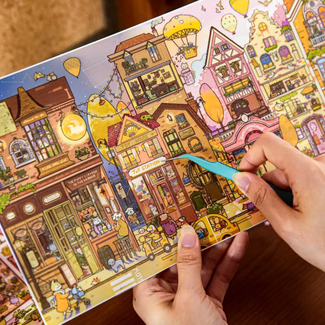 Hands placing a sticker onto the Tail Street Never Sleeps scene backboard