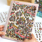 A city scene page from the Telado People Everywhere 3D Scene Sticker Book held in hand