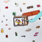 Close-up of a pre-cut television sticker piece being lifted with tweezers