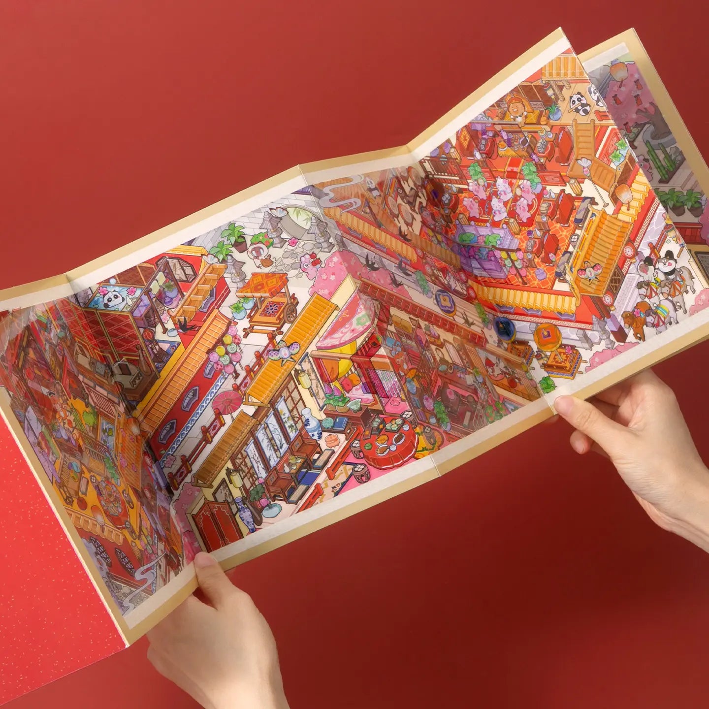Hands opening the Vermilion Pavilion accordion-style fold-out scene display