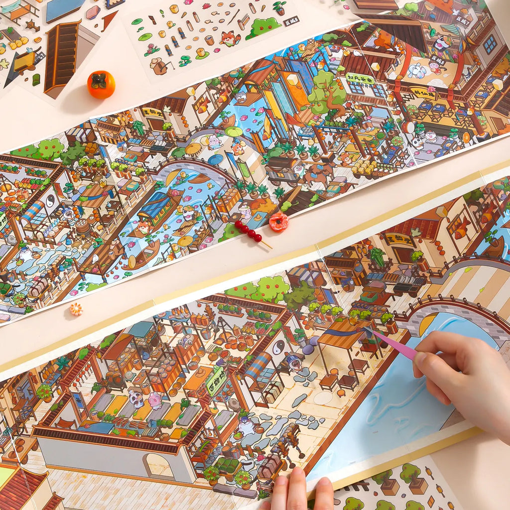 Hands building the Vermilion Pavilion fold-out scene with flat PET stickers