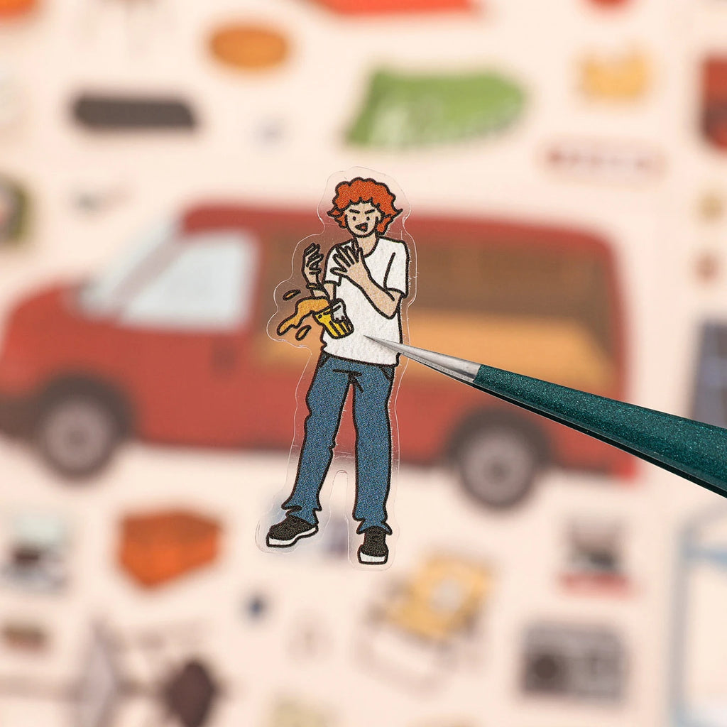 Small character sticker being held with tweezers for the Vintage American Afternoon Park scene sticker kit