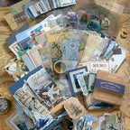 Warm Postal Journey Junk Journal Kit travel ephemera flat lay with papers, memo sheets, stickers, and cards