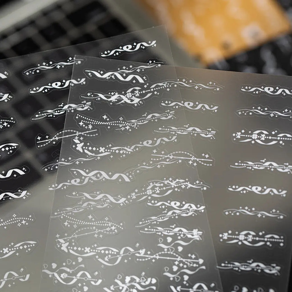 Close-up of white border and flowing line PET stickers for journal and collage decoration